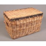 A large twin handle wicker basket. (Height 54cm, Width 90cm, Depth 60cm).