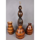 An exotic hardwood table lamp with similar and matching vases.