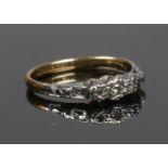 An 18ct gold and platinum ring set with three diamonds. Size J 1/2, 2.05g.