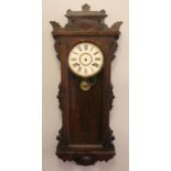 An Ansonia Clock Co carved mahogany wall clock. Top left corner of the clock case is broken, not