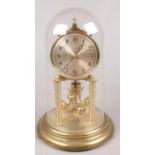 A German brass torsion clock under dome.