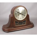 A carved mahogany eight day chiming mantle clock with silvered dial. Pendulum and key present.