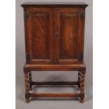 A carved oak side cabinet with fitted interior. Raised on barley twist support. (91cm x 56cm)