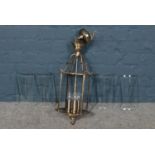 A brushed brass frame lantern - with four curved and bevelled glass panels. H: 63cm, W:25cm.