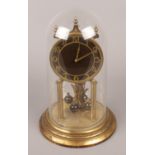 A Kieninger and Obergfell brass torsion clock with enamel dial.