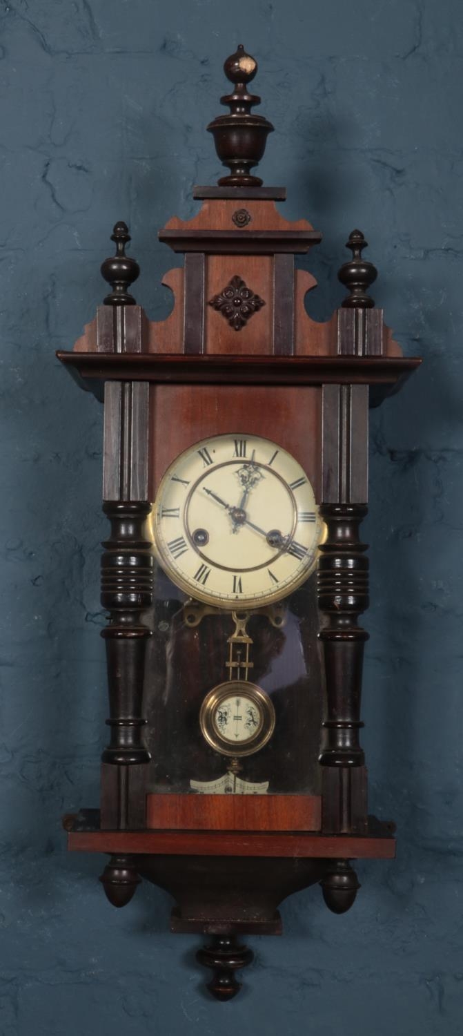 A mahogany cased wall clock. Chiming on a coiled gong. With pendulum and key. Top pediment loose.