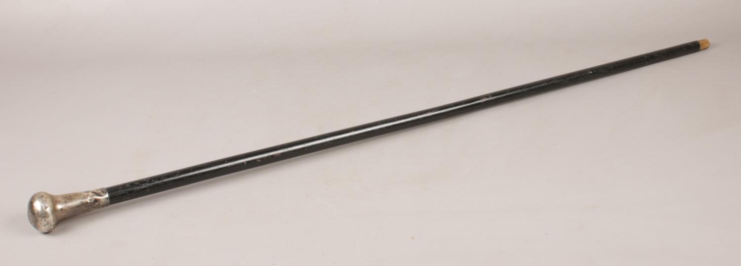 A ebonised walking cane with silver pommel.