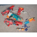 A box of toy guns. Includes Nerf and Boom Co examples.