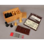 A boxed set of weighted chess pieces, along with darts and dominoes.