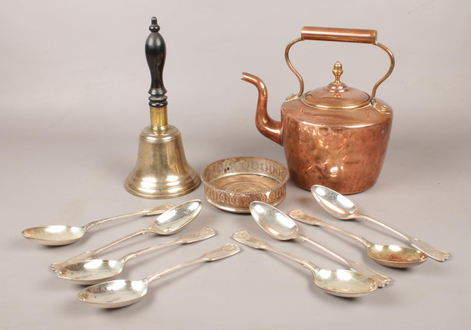 A group of metalwares. Includes copper kettle, hand bell, Mappin & Webb spoons, wine coaster.