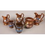 A quantity of copper lustre jugs. Including set of 3 graduated examples, etc.