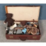 A leather suitcase with contents. Includes soft toys, kitchenalia etc.