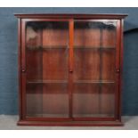 A mahogany floor standing display cabinet. With double sliding doors. (132cm x 132cm x 38.5cm)