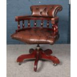 A brown leatherette deep button swivel office chair. Wear to arms.