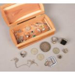 A wooden box of mainly silver items. Includes charms, Victorian crown, rings etc.