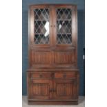 A carved oak wall unit. Comprising of lead glazed top, drink cabinet, cupboard base with linen