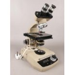 A Vickers instruments electric binocular microscope. B.D.U.S 66 - H: 39cm, W: 18cm. Vendor