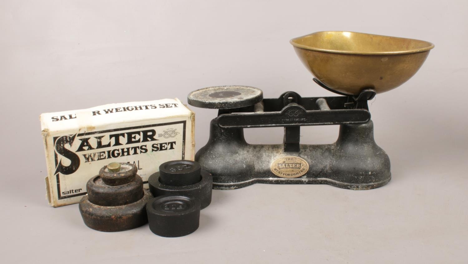 A set of antique ' The Salter ' balance scales. an ebonised cast iron base with brass tray to