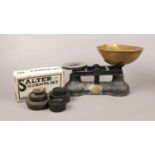 A set of antique ' The Salter ' balance scales. an ebonised cast iron base with brass tray to