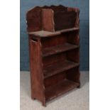 A mahogany and oak open bookcase with magazine rack top.