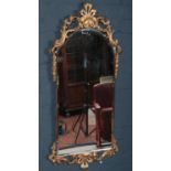 A large ornate bevel edged gilt framed hall mirror. (103cm x 46cm)