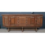 A carved and panelled oak sideboard. (187cm x 80cm x 47cm)