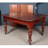 A Victorian mahogany wind out dining table with extra leaves and winding handle.