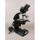 A Vickers instruments electric binocular microscope. H: 35cm, W: 18cm. Vendor confirms this item