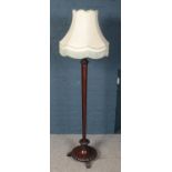 A carved mahogany tapering standard lamp raised on 3 claw feet.