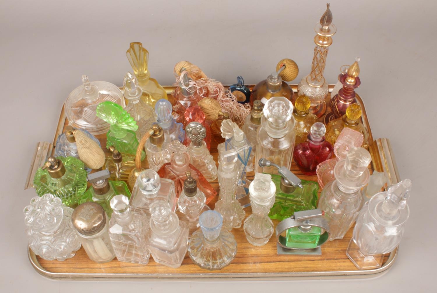 A tray of various glass scent bottles. Including coloured glass examples, etc.