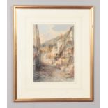 Gilt framed watercolour of a cobbled street with figure and donkey, indistinct signature bottom