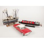 A Road Signature model car, along with two wooden models of boats.