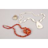A small collection of jewellery. Includes amber coloured beads, carved bone necklace and a frosted