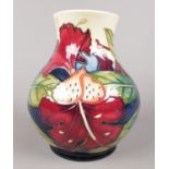 A Moorcroft vase with painted lilies - 'Simeon' by Phillip Gibson. H: 16cm. (Unboxed). Condition