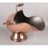 A copper and brass coal scuttle with stepped base.