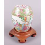 A Chinese famille rose barrel shaped jar decorated with figures. Crack through lid. Chips to