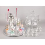 A collection of mostly glassware. Includes etched glass punch bowl and glasses, cocktail shaker,