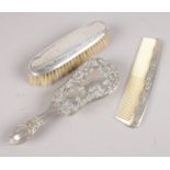 A silver mounted brush along with a white metal comb and hair brush. Assayed Chester 1922.