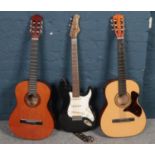 Two acoustic guitars along with a Stratocaster style electric guitar.