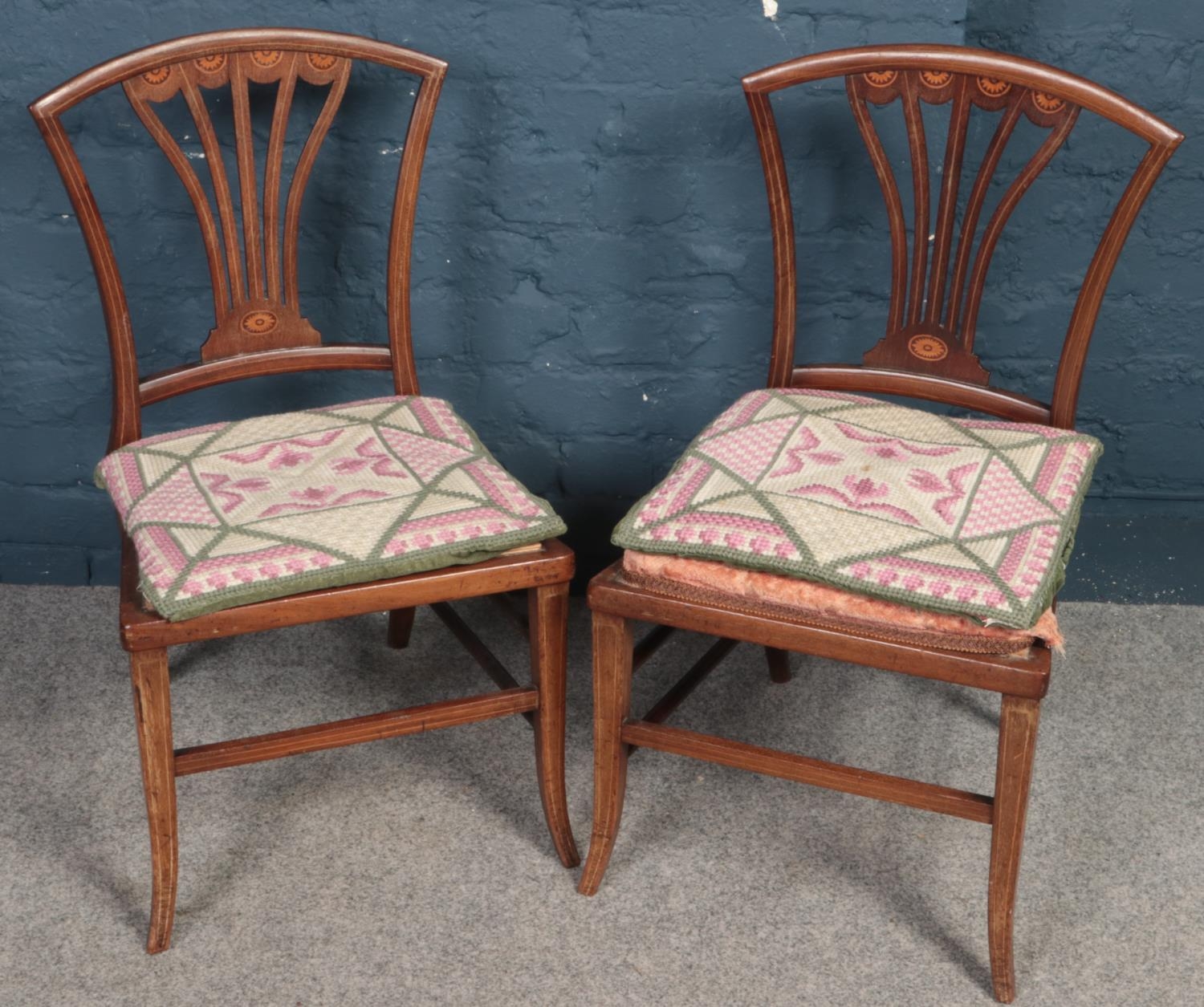 A pair of Edwardian inlaid mahogany pierced back nursing chairs.