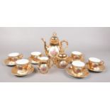 A gilt lustre coffee set. Decorated with transfer printed panels, scene with two lovers.