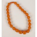 A spice Amber necklace, comprising of 25 graduated beads with screw cup fastener, 53 cm long, widest