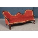 An upholstered child's two seat sofa with carved mahogany frame. (Height 47cm, Length 113cm).