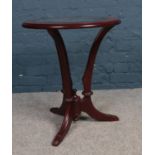 A Mahogany round glass topped occasional table. Comprising of bevelled glass and three legs. H: