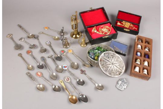 A group of collectables. Includes filigree box, collector's spoons, thimbles, miniature musical