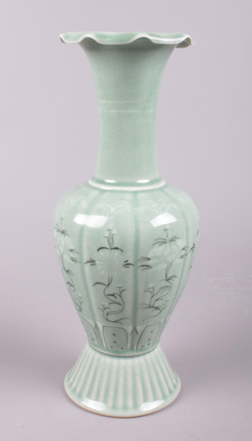 A Chinese celadon coloured vase. Character marks to the base. (Height 26cm).