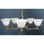 A 5 arm brass chandelier with glass bowl shades.