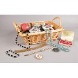 A basket of costume jewellery. Beads, Necklaces, brooches examples etc.