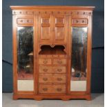 A Victorian satinwood compactum with figured ash panels and mirrored doors.