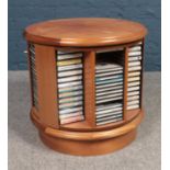 A teak revolving CD/cassette tape stand. With contents.